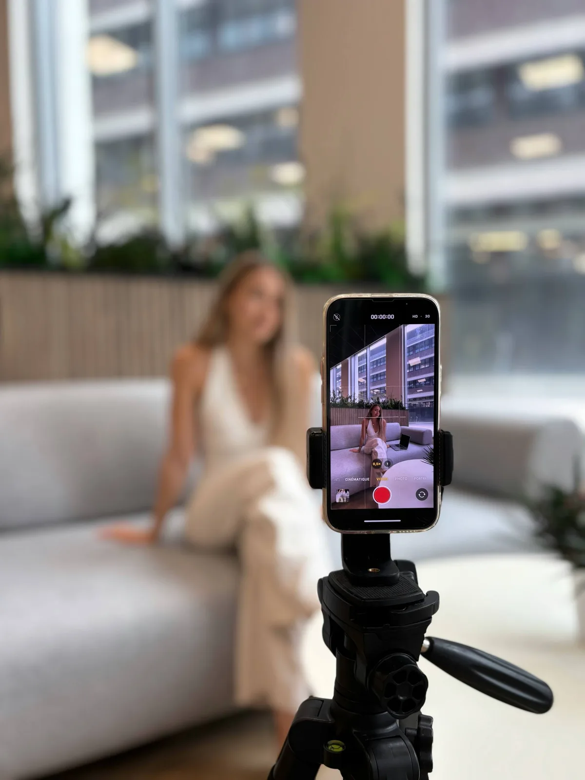 Phone filming a woman seated on a sofa